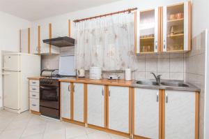 eine Küche mit einer Spüle, einem Herd und einem Kühlschrank in der Unterkunft House Jozo in Marina + 3 Fotos