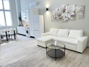 uma sala de estar com um sofá branco e uma mesa em Ribera Home em Córdoba
