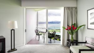 a living room with a sliding glass door leading to a balcony at Grand Pacific Hotel in Suva