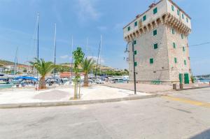 ein hohes Gebäude neben einem Jachthafen mit Palmen in der Unterkunft House Jozo in Marina