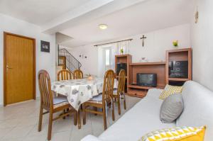ein Wohnzimmer mit Tisch und Stühlen und einer Couch in der Unterkunft House Jozo in Marina