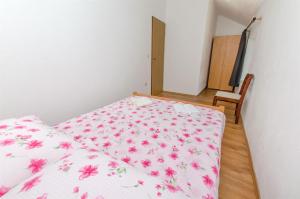 a bedroom with a bed with pink flowers on it at House Jozo in Marina