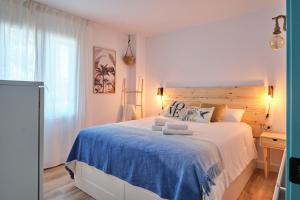 ein Schlafzimmer mit einem großen Bett mit einer blauen Decke in der Unterkunft Dolce Barbera 15 min to Barcelona and beach in Barberà del Vallès