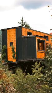 a black and orange house sitting on a hill at bungalove tatil köyü in Çamlıhemşin