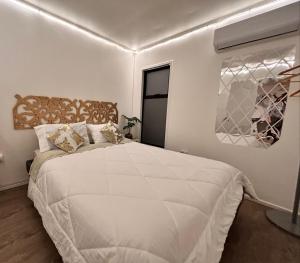 a bedroom with a large white bed in a room at Estadía en Villa alemana Opción a jacuzzi Golden BeeHouse in Villa Alemana