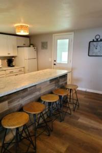 a kitchen with a counter and stools in a room at Cottage on Shawano Lake. On The Beach in Shawano