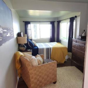 a bedroom with a bed and a couch with a chair at Cottage on Shawano Lake. On The Beach in Shawano