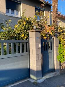 a blue fence with a blue door and a hedge at les alouettes in Aurillac