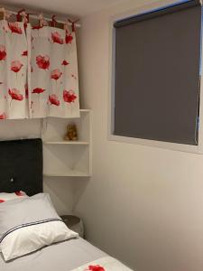 a bedroom with a bed and a window with a curtain at les alouettes in Aurillac