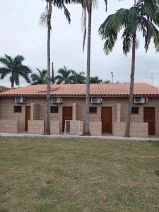ein Gebäude mit Palmen davor in der Unterkunft Casa das Pedras in Caraguatatuba