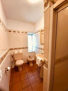 a bathroom with a toilet and a sink and a tub at Casa Pereiro playa de Esteiro in Viveiro