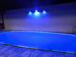 eine blaue Badewanne in einem Zimmer mit Beleuchtung in der Unterkunft Casa das Pedras in Caraguatatuba + 7 Fotos