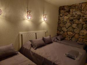 ein Schlafzimmer mit einem Bett und einer Steinwand in der Unterkunft Casa das Pedras in Caraguatatuba