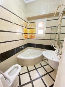 uma casa de banho com uma banheira, um WC e um lavatório. em فيلا اول صف بحر مارينا الساحل الشمالي العلمين برايفت بول em El Alamein