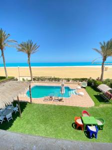 a resort with a swimming pool and a beach at فيلا اول صف بحر مارينا الساحل الشمالي العلمين برايفت بول in El Alamein