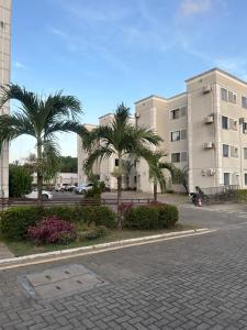 a parking lot with palm trees in front of a building at Apt da Leily in São Luís