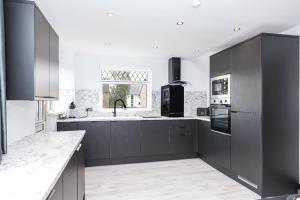 a kitchen with black and white cabinets and a window at Doralan in Bishopbriggs