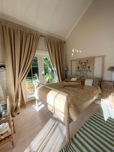 a bedroom with a large bed and a large window at Villa Tilda in Mathildedal