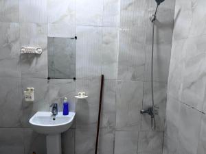 a bathroom with a sink and a shower with a mirror at Short Stay Apartment in Dubai