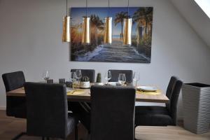 a dining room with a table and a painting of a pier at Wohnung in Eggenstein-Leopoldsh. 