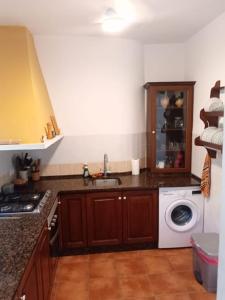 eine Küche mit einer Spüle und einer Waschmaschine in der Unterkunft Casa en el valle de GuainosAltos in Adra