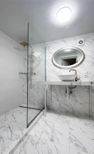 Baño blanco con lavabo y espejo en KING Apartments in city centre, en Leópolis