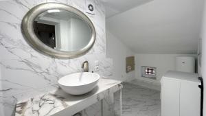 Baño blanco con lavabo y espejo en KING Apartments in city centre, en Leópolis