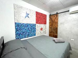 Cama en habitación con bandera en la pared en OyeBonita Hostel en Panamá