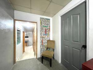 - un couloir avec une porte et une chaise dans la chambre dans l'établissement OyeBonita Hostel, à Panama City