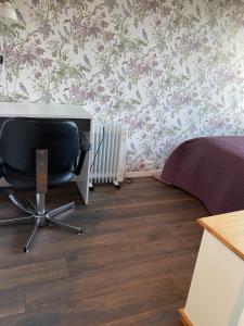 1 dormitorio con escritorio y silla junto a la cama en comfortable apartment in a quiet area in the city center, en Skien