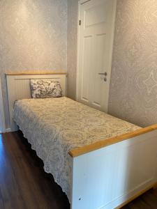 a small bedroom with a bed with a white bed frame at comfortable apartment in a quiet area in the city center in Skien