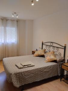 a bedroom with a bed with pillows and a window at Apartamentos Canana de Vega in Flix