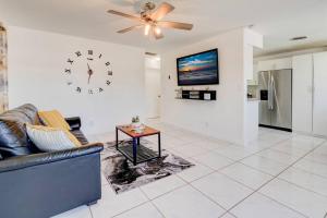 a living room with a couch and a clock on the wall at Sunrise Getaway in Sunrise