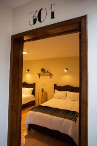 - une chambre avec un lit et un grand miroir dans l'établissement Casa Venus, à San Cristóbal de Las Casas