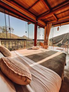 1 cama grande con almohadas en una habitación con vistas en Rustik en Alto Paraíso de Goiás