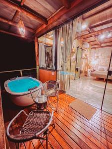ein großes Bad mit einer Badewanne und einer Glasdusche in der Unterkunft Rustik in Alto Paraíso de Goiás