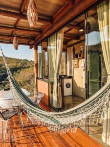 a hammock on the deck of a house at Rustik in Alto Paraíso de Goiás