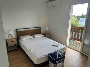 une chambre avec un lit et un balcon dans l'établissement Maison 100m2 4 chambres avec piscine jardin paysage, à Gujan-Mestras 6 autres photos