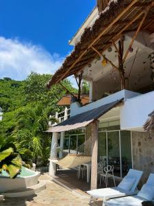 uma casa com um alpendre com cadeiras e um baloiço em Villa de Reyes Hotel Boutique em Acapulco