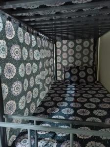 een bed in een kamer met een muur met patronen bij The Sky Hosteller Dubai in Dubai