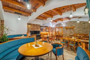 um restaurante com mesas de madeira e cadeiras azuis em Hotel Orličan em Rokytnice v Orlickych Horách