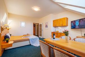 une chambre avec un lit, une table et une salle à manger dans l'établissement Hotel Orličan, à Rokytnice v Orlických Horách