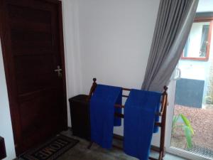 a room with blue cloths on a chair next to a door at COCO RELAX AYURVEDA VILLAS in Hikkaduwa