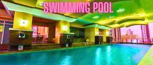 a swimming pool in a building with a hotel at Family Room Affordable, Cheapest Deluxe Double Unit in Manila with 2 Balconies & 2 Bathrooms 25 Percent Discount, Free Sauna & Pool Access Near Manila Bay, Robinsons Place Ermita, Pgh, Bellagio, UP, Pedrogil, US Embassy, NAIA Airport Updated 2024 in Manila