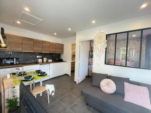 a kitchen and living room with a couch and a table at Petite maison Disneyland Paris in Magny-le-Hongre