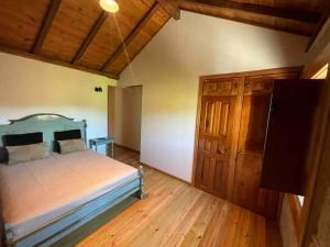 a bedroom with a bed and a wooden floor at Petra's House Gerês in Geres