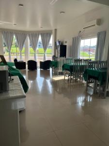 a dining room with green tables and chairs and windows at Hotel Paraná Portal in Marechal Cândido Rondon