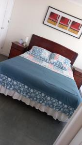 Un dormitorio con una cama con un edredón azul. en Depto La Serena frente al mar, en La Serena