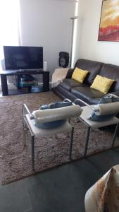 Una sala de estar con dos sillas y un sofá. en Depto La Serena frente al mar, en La Serena