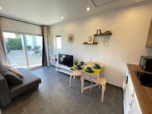 a kitchen and living room with a table and a couch at Petite maison Disneyland Paris in Magny-le-Hongre